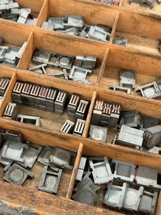 Metal type laid out letter by letter in a wooden tray