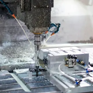 A CNC machine cutting a steel component with coolant running