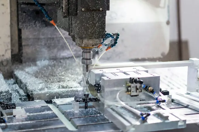 A CNC machine cutting a steel component with coolant running