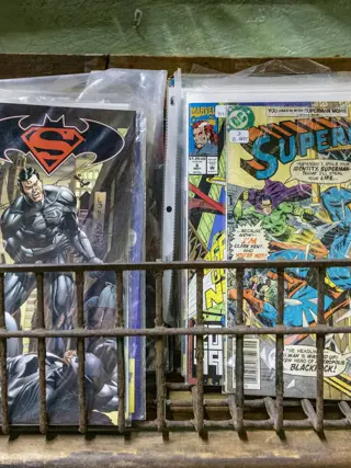 A wire basket of back issues in bags and boards