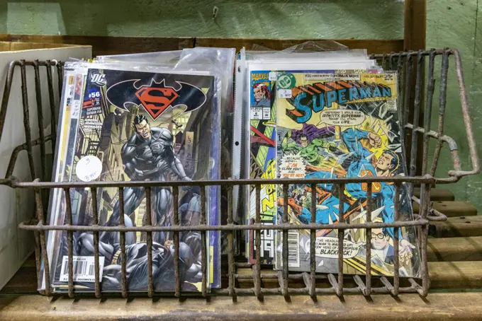 A wire basket of back issues in bags and boards