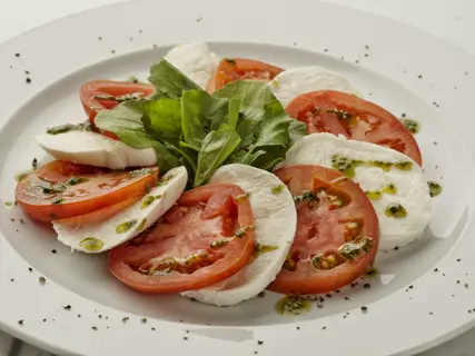 Tomatoes, basil and mozzarella laid out on a board