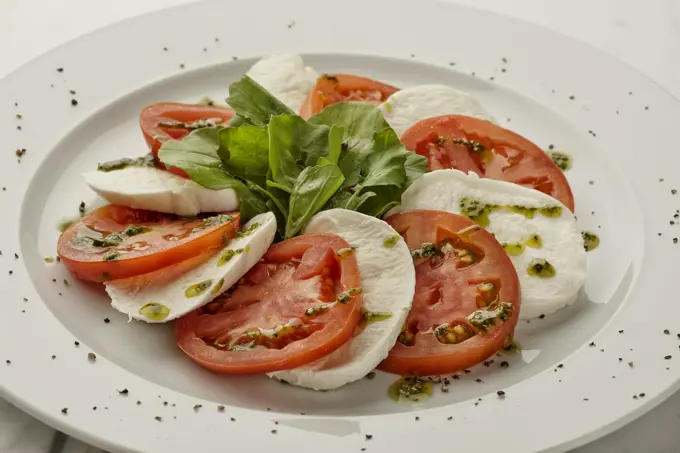 Tomatoes, basil and mozzarella laid out on a board