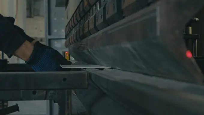 A brake press folding a steel plate along a marked line