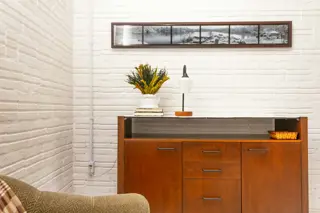 A lamp on a sideboard in a low-lit room