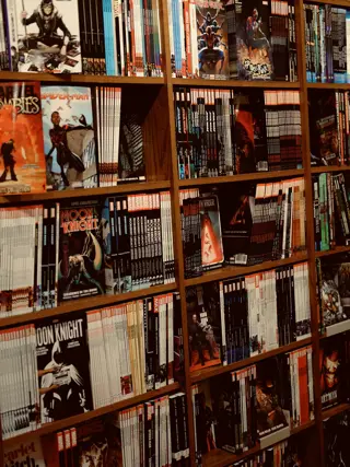 Floor-to-ceiling shelving packed with comics, spines out
