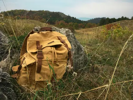 A canvas rucksack propped against a wall outdoors