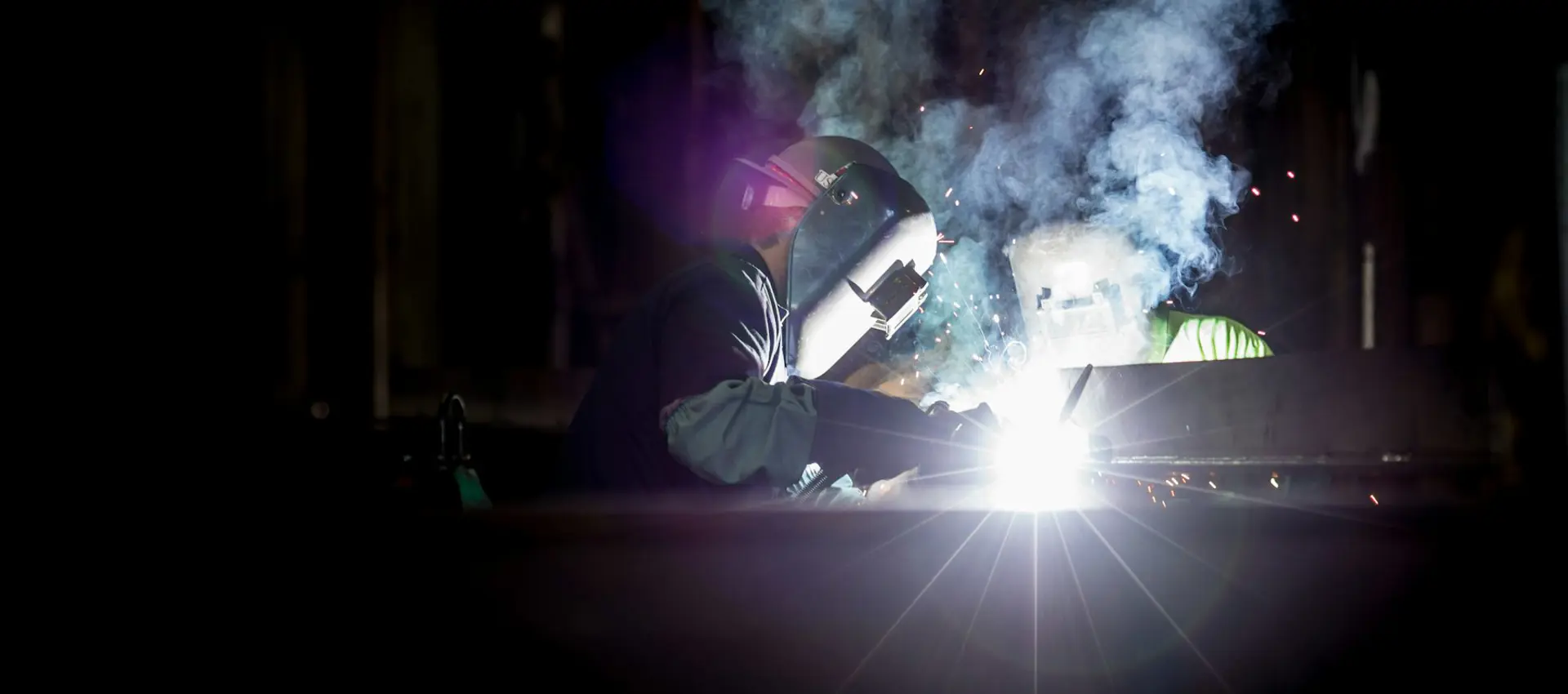 A welder laying a bead along a heavy plate seam