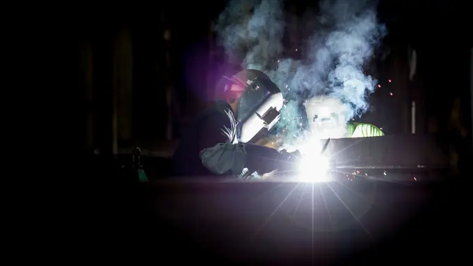 A welder laying a bead along a heavy plate seam